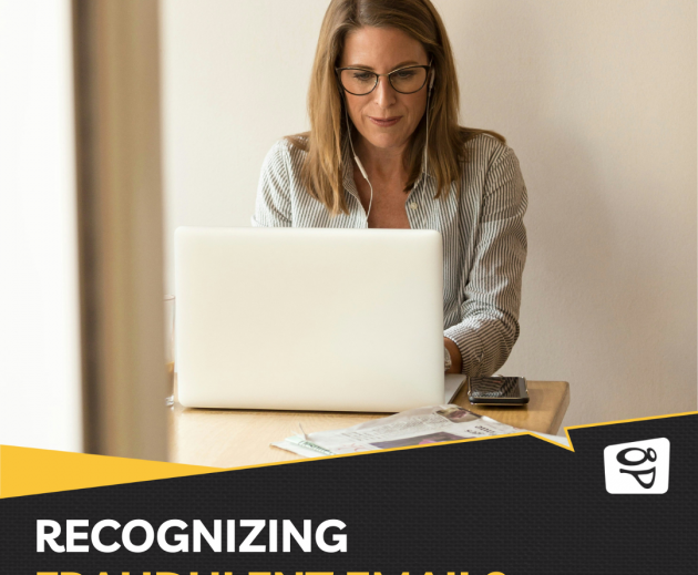 women sitting at wood table on her laptop wearing earbuds